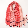 Dettaglio di sciarpa in cotone e lino rosso e crema con motivi geometrici e nappe - 180x90 / Rosso