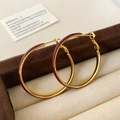 Detail van elegante gouden creolen met bordeauxrood emaille in een luxe sieradendoos - Ancorra Rood
