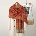 Ethnic paisley embroidered scarf with tassels in deep red and gold over a beige coat - Red Camel