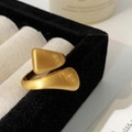 Primer plano detallado de un anillo abierto dorado con textura cepillada sobre terciopelo - Dorado