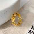 Detailed close-up of a gold hollow geometric flower ring on a natural linen background - Gold Hollow Flower Ring