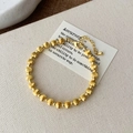 Dettaglio del bracciale a sfere dorate opache e lucide con chiusura a moschettone - Bracciale Oro