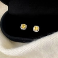 Gros plan de boucles d'oreilles halo en zircone jaune de coupe carrée dans un coffret - Clous en Zircon Jaune Argenté