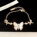 Détail d'un bracelet papillon doré avec incrustation de nacre et zircons étincelants - Bracelet papillon doré