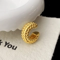 Dettaglio di un ear cuff a C placcato oro con superficie testurizzata a perline fitte - Oro