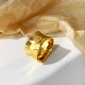 Detailopname van een dikke goudkleurige ring met een onregelmatig golvend ontwerp - Goud
