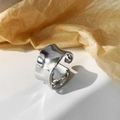 Macro-opname van brede onregelmatige zilveren ring met golfvormige randen en glans - Zilver