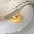 Macro di anello dorato a doppio strato ondulato con apertura regolabile su ceramica - Orecchino a Clip a Onda a Doppio Strato / Oro
