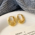 Vista dettagliata degli orecchini a cerchio a U intrecciati placcati in oro con trama a spirale - Oro