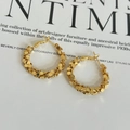Macro shot of gold twist earrings with faceted glitter texture on fashion magazine - Gold Shattered Silver Earrings