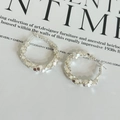 Close-up of silver hoop earrings with shimmering scale texture on magazine background - Silver Shattered Silver Earrings