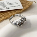 Close-up of polished silver multi-layer ring with decorative small hoops on porcelain dish - Three-Ring Layered Winding Style / Silver