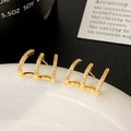 Macro detail of gold-plated curved claw earrings with three rows of micro-inlaid zircons - Gold