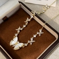 Macro shot of gold butterfly necklace with mother of pearl wings in jewelry gift box - Seven Butterflies Style / Gold Multiple Butterflies Necklace