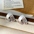 Dettaglio macro di orecchini a triangolo argento con eleganti motivi leopardati vintage - Triangolo / Argento Leopardato