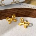 Vue détaillée de boucles d'oreilles nœud en or mat sur tissu en lin blanc - Noeud Papillon Mat / Doré