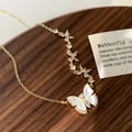 Detail of gold butterfly necklace featuring white shell wings and shimmering zircon accents - Triple Butterfly Style / Gold Three Butterflies Necklace
