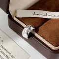 Macro-opname van een zilveren onregelmatige oormanchet op een luxe sieradendoosje van leer - Zilver