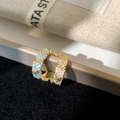 Detail of gold hoop earrings with turquoise beads and zircon stones on a display stand - Gold Blue Zirconia Ear Cuff