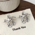 Irregular silver flower earrings with wavy textures on white textured paper - Silver