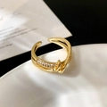 Detail of gold-plated double-row crossover ring featuring micro-pave zirconia stones - Cross Intertwined Micro Pave Ring / Gold