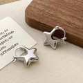 Close-up of polished star-shaped silver earrings with snap closure on a rustic setup - Star Hoop / Silver