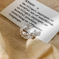 Macro shot of silver multi-layer ear cuff with chain texture on vintage paper background - Silver