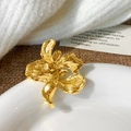 Broche fleurie dorée exquise avec finition mate et texture organique sur une assiette - Bague Fleur Dorée (C-406)