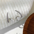 Dettaglio del polsino per orecchio in argento texture serpente con zirconia a goccia - Stile Goccia d'Acqua con Trama di Serpente Argentata