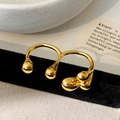 Macro shot of liquid metal style double ring with golden teardrop spheres in warm lighting - Multi-finger Ring / Gold