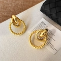 Détail de boucles d'oreilles doubles cercles dorés avec texture torsadée et anneau poli - Doré
