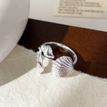 Detailed close-up of a silver adjustable ring featuring sea shell and conch motifs - Silver