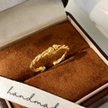 Detailed macro view of gold twisted rope knot ring on brown velvet jewelry box - Twisted Rope Open Style / Gold