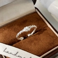 Macro shot of silver twisted rope ring with bow charm in a velvet jewelry box - Twisted Rope Open Style / Silver