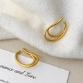 Detailansicht der mattgoldenen doppelten Ohrmanschetten auf weißem Strickgewebe - Matte Gold Ohrmanschette