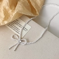 Collier de perles élégant de style français avec pendentif nœud brillant sur lin - Style Noeud en Perle