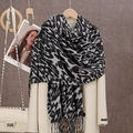 Detalle de bufanda con estampado de leopardo y flecos sobre abrigo beige de cachemira - Leopardo Negro Gris