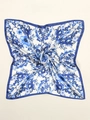 Detailed macro view of floral pattern and smooth satin texture on the square silk scarf - Blue