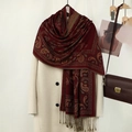 Dettaglio di sciarpa rossa con ricamo paisley e nappe annodate a mano su cappotto bianco - Rosso Vino