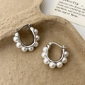 Macro di orecchini a forma di U in argento con perle bianche su sfondo strutturato - Argento