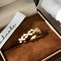 Detail shot of a golden bow ring with white crystal inlay on a velvet jewelry box - C-137 Row Bow Style (C-137) / White