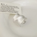 Minimalist brushed silver wide ring with wavy texture shown on white porcelain plate - Silver Brushed Ring