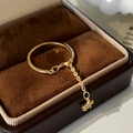 Macro shot of gold ring with a dangling star charm and chain detail on velvet - Gold Star Pendant Ring