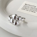 Detailed view of silver heart rings with a polished mirror finish on a white plate - Heart Shaped Open (Silver) / Silver