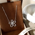 Dettaglio del ciondolo a fiore in argento con zirconi su scatola porta gioielli marrone - Argento