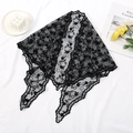 Elegant black lace headscarf with hollow floral patterns on white draped fabric - Black