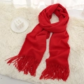 Solid red winter scarf with soft fringe tassels on a cozy white fur background - Red
