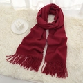 Deep red soft winter scarf with tassels placed on a white plush rug for styling - Wine Red
