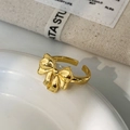 Close-up of golden bow ring with beaded edge details and adjustable open band design - Gold Bowknot Ring