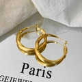Detailaufnahme großer gedrehter goldener Creolen mit strukturierter Bürstenoptik - Gold Gebürstet Creolen